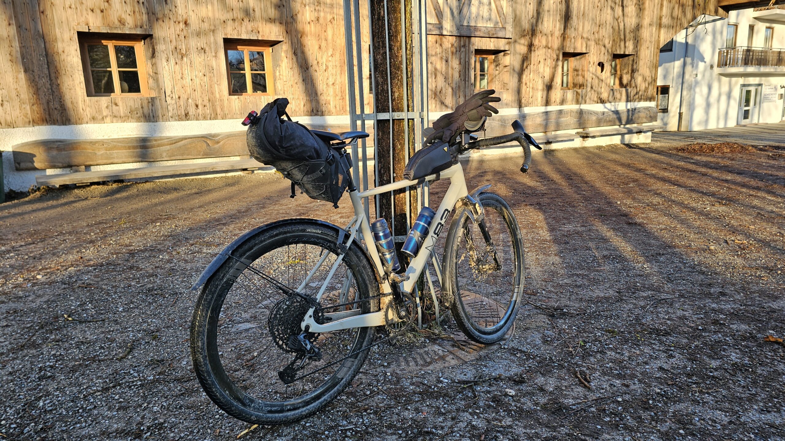 Bepacktes Gravelbike vor einer alten Holzscheune