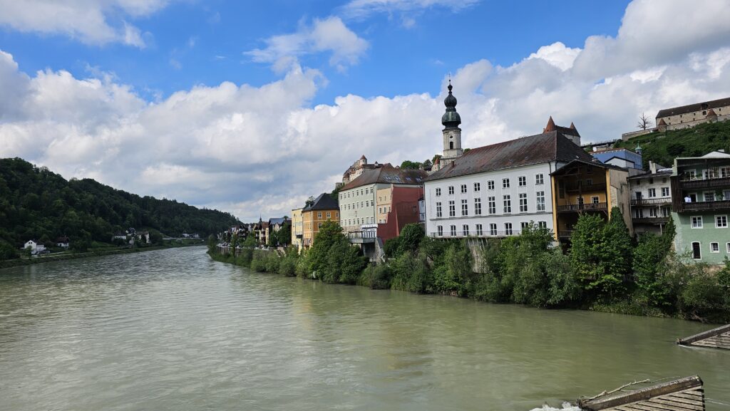 Altstadthäuser mit Kirchturm direkt am Flussufer