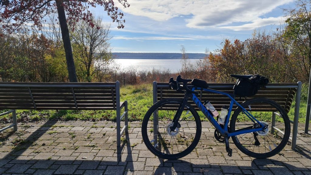 Gravelbike an einer Bank am See