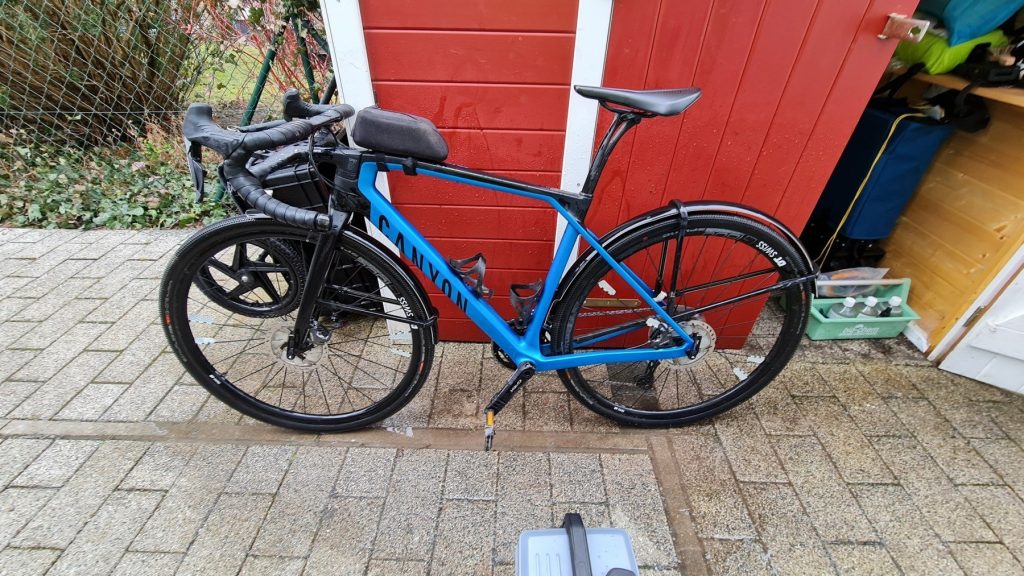 Gravelbike vor einer roten Gartenhütte