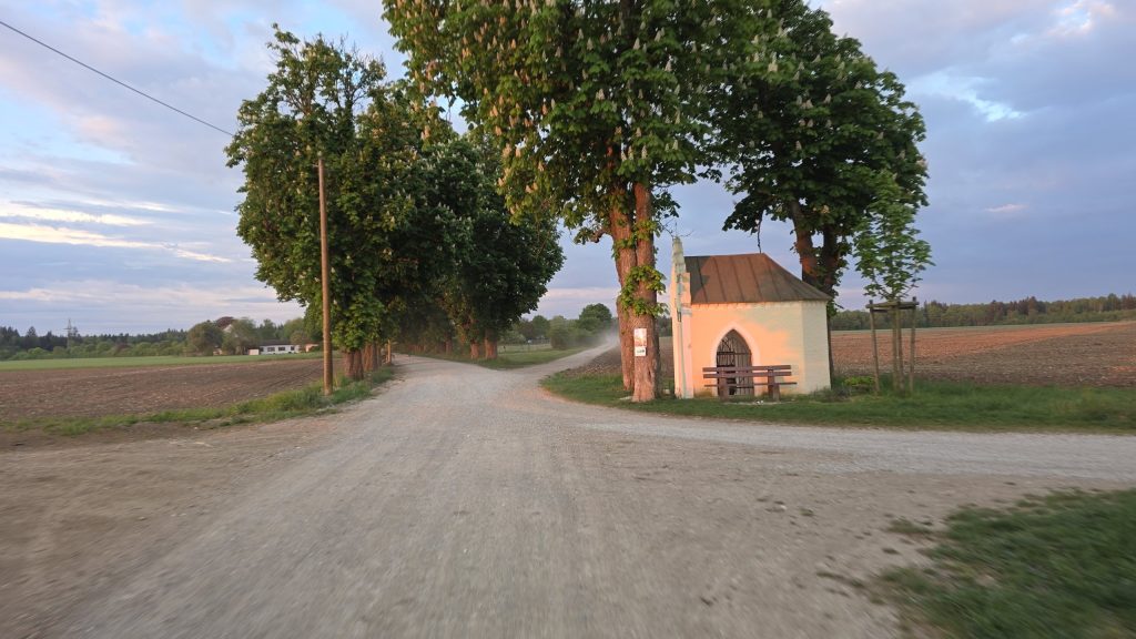 Kleine Kapelle an einem Schotterweg im Morgenlicht