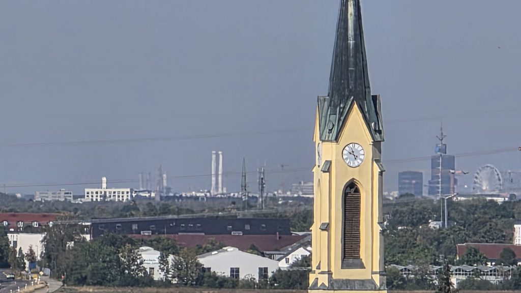 Kirchturm von Neufarn mit Münchner Skyline